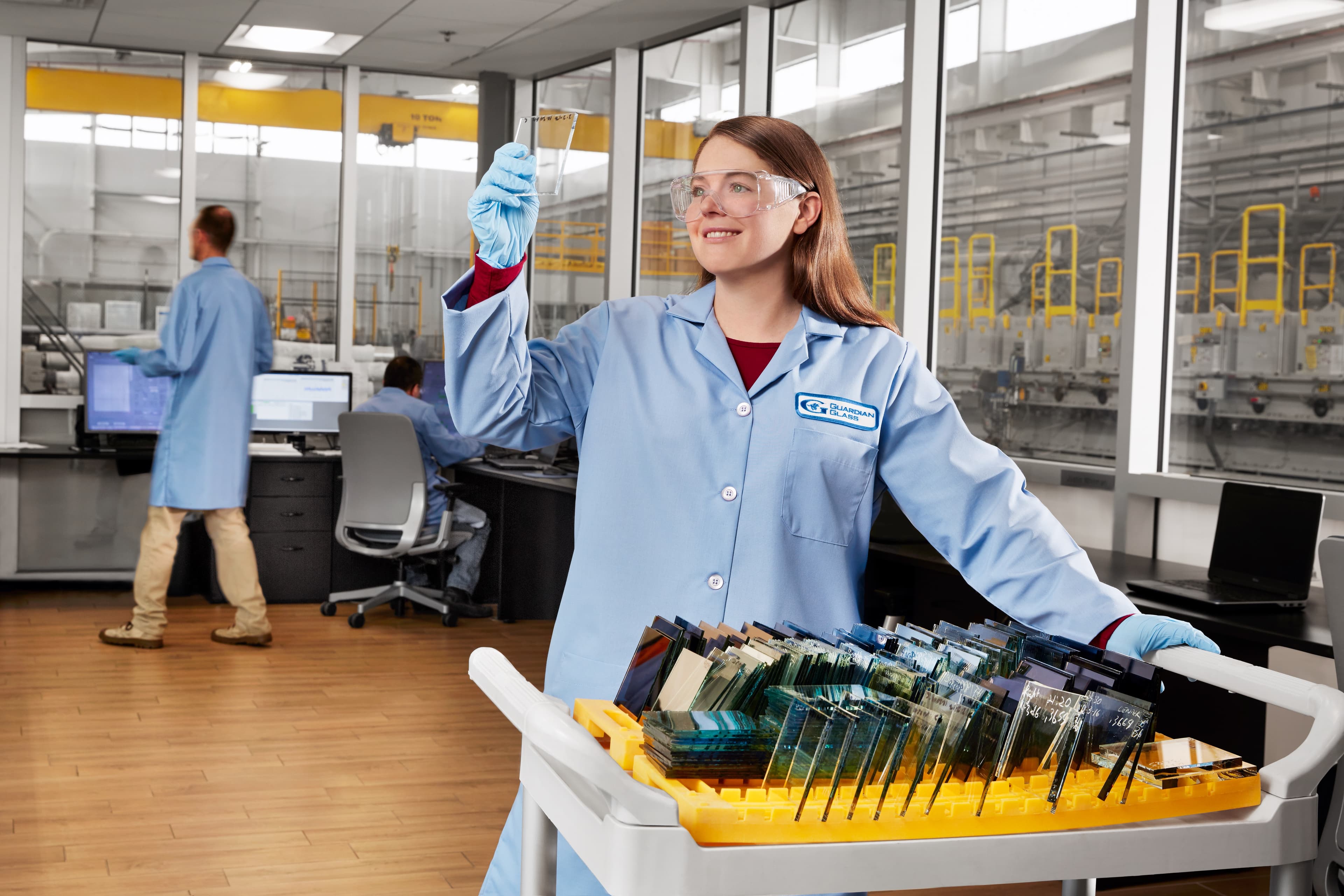 Scientist holding a glass sample in a Guardian Glass facility