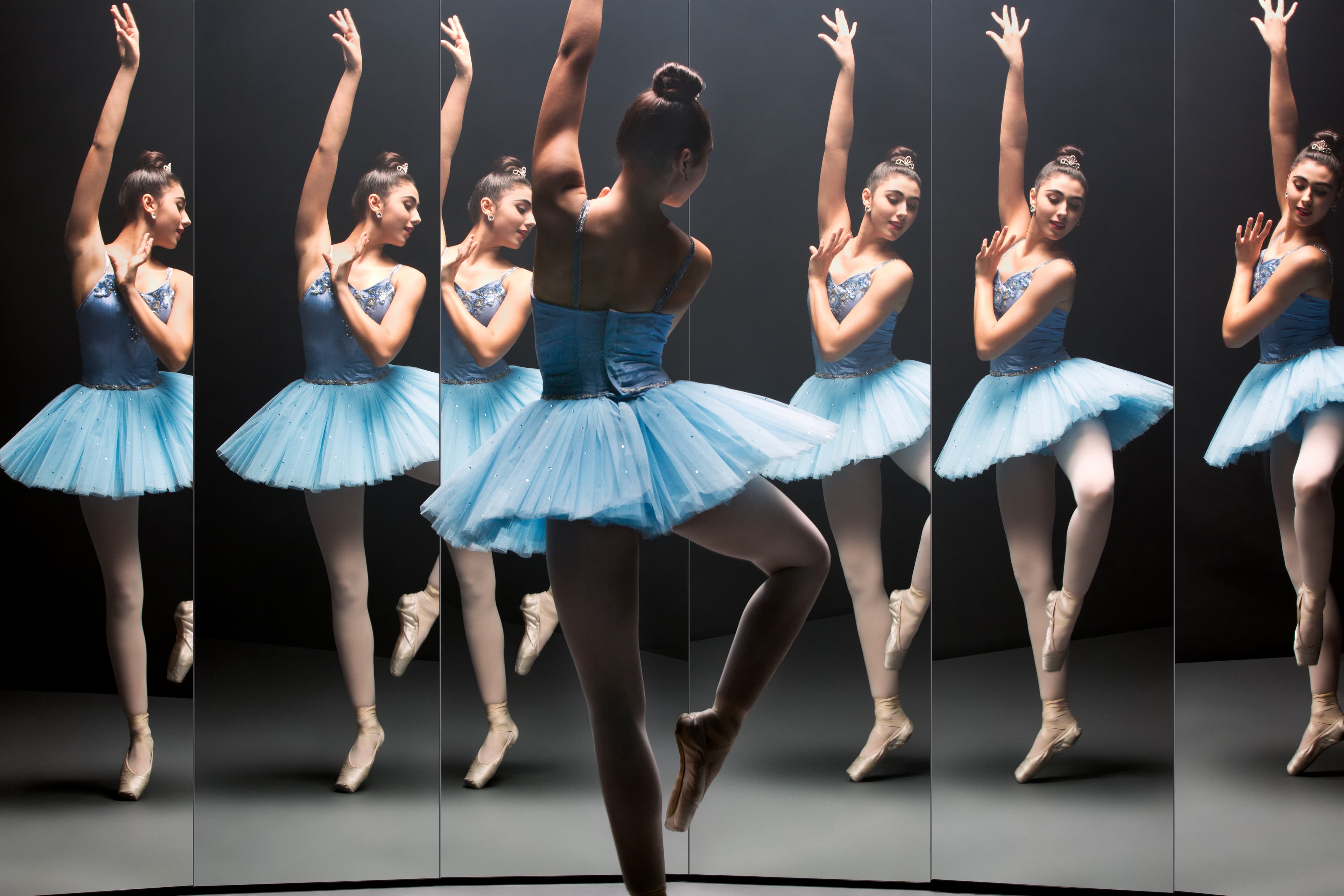 Ballerina dancing in front of many mirrors