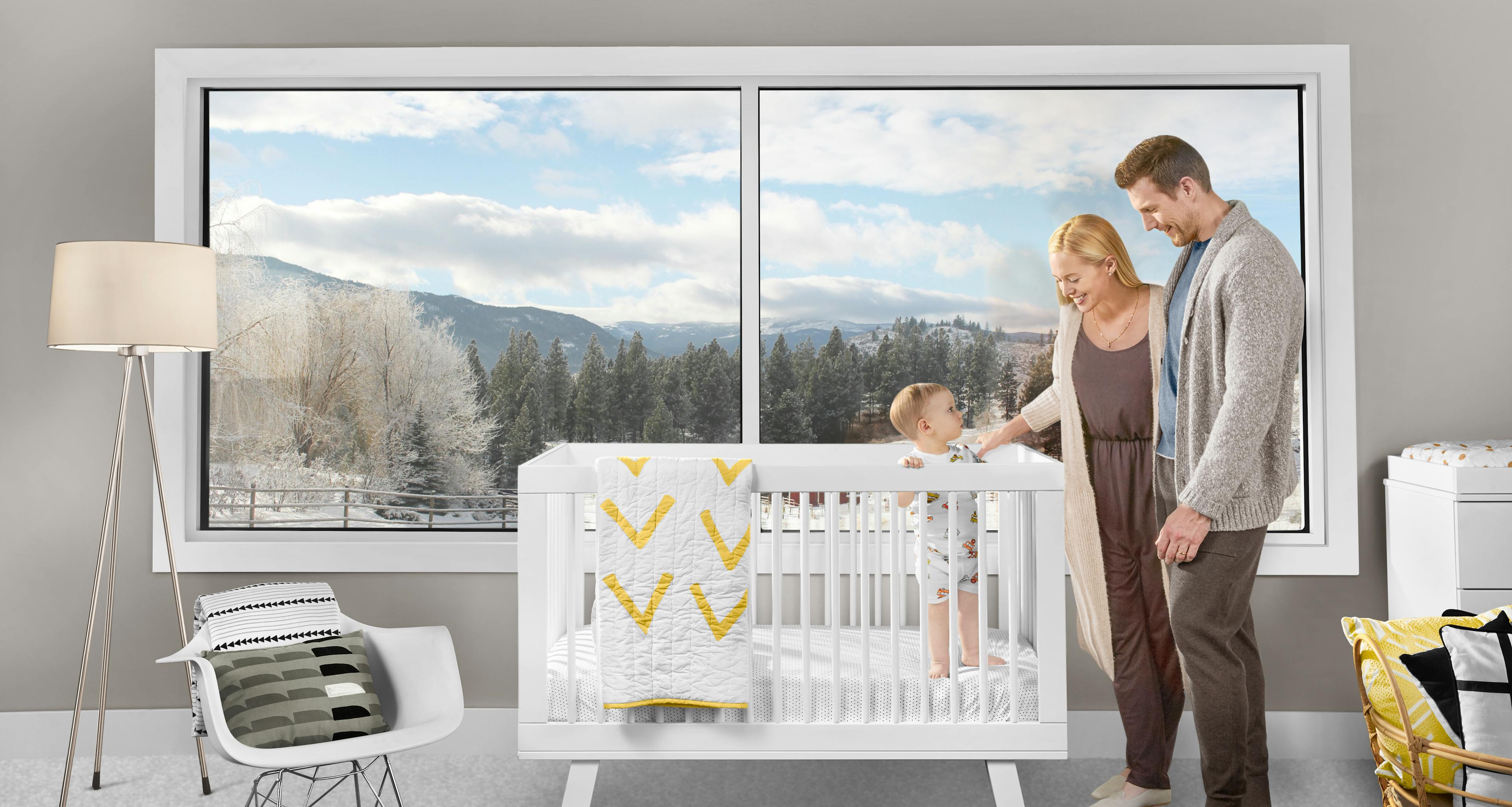 Family with baby in front of large window